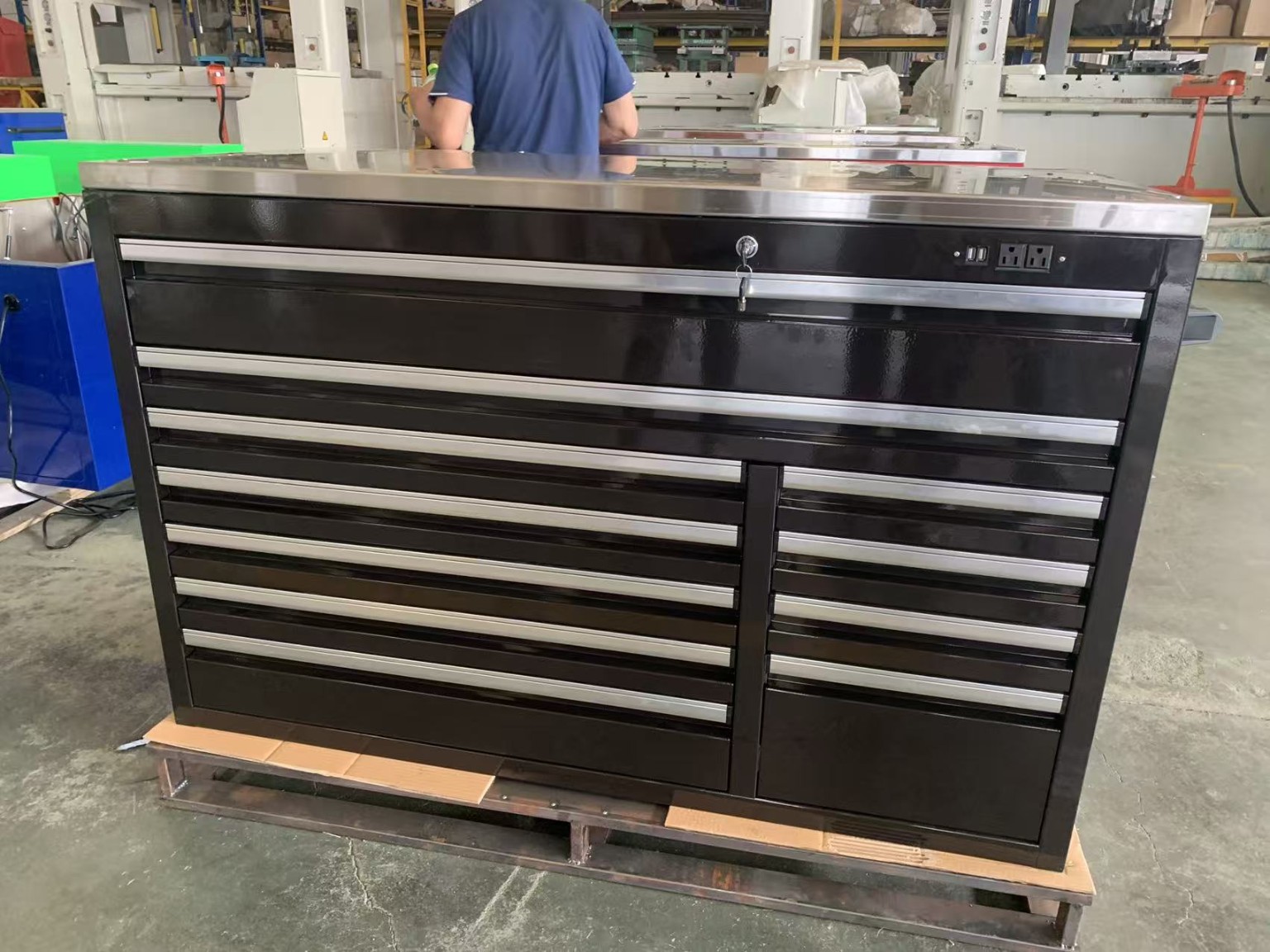 Heavy-duty black steel tool chest with stainless worktop and power outlets in Qingdao workshop