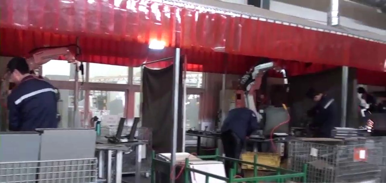 Welding station with sparks under red curtains